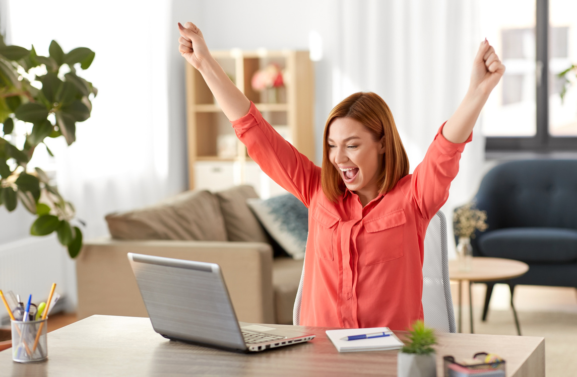 Happy Woman with Laptop Working at Home Office